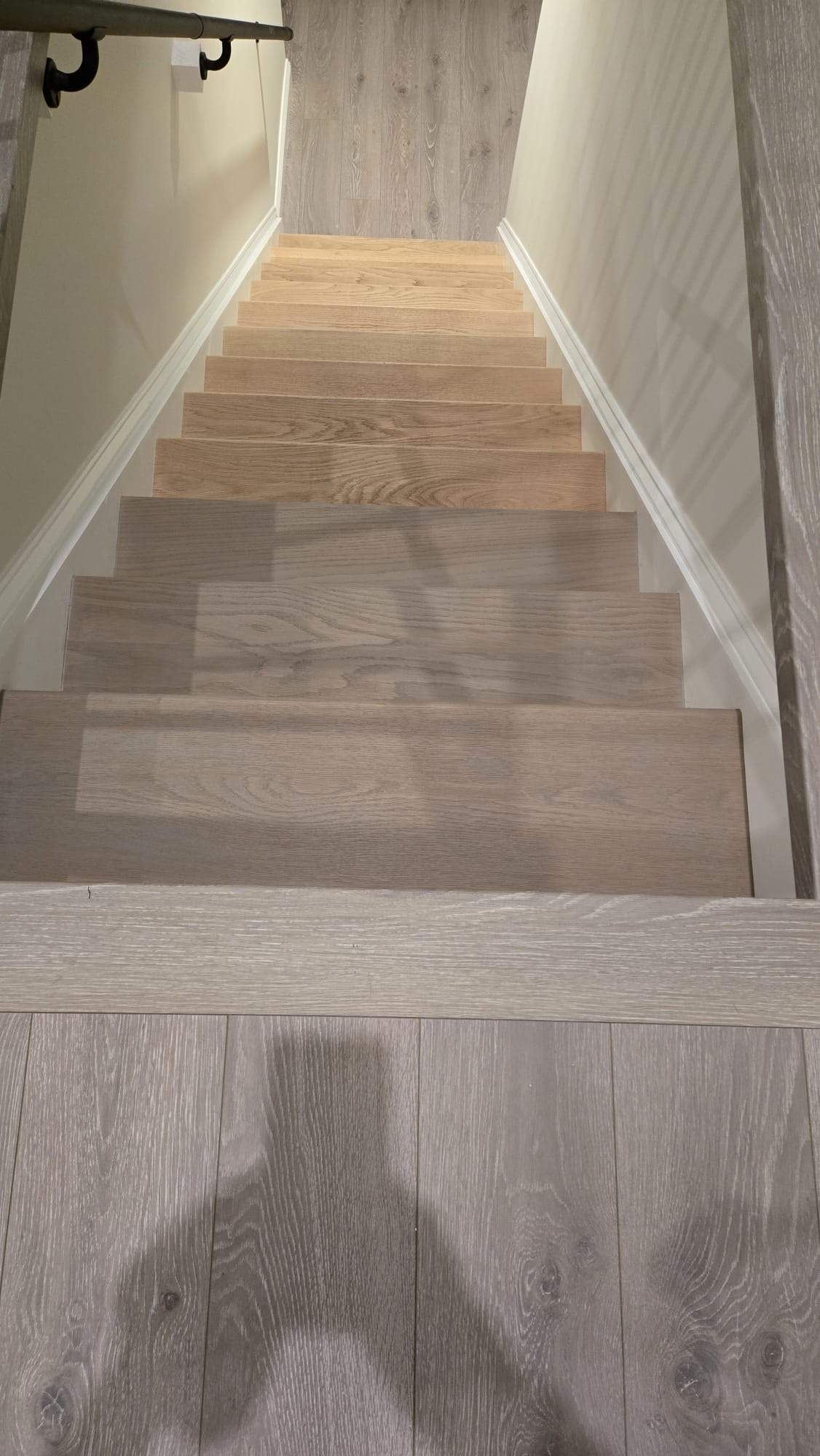 Refinished hardwood staircase with light gray wood flooring