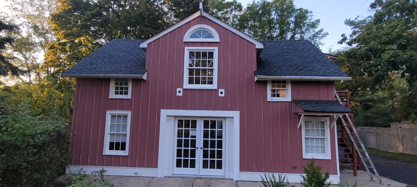 Red barn-style home exterior with white trim and French doors