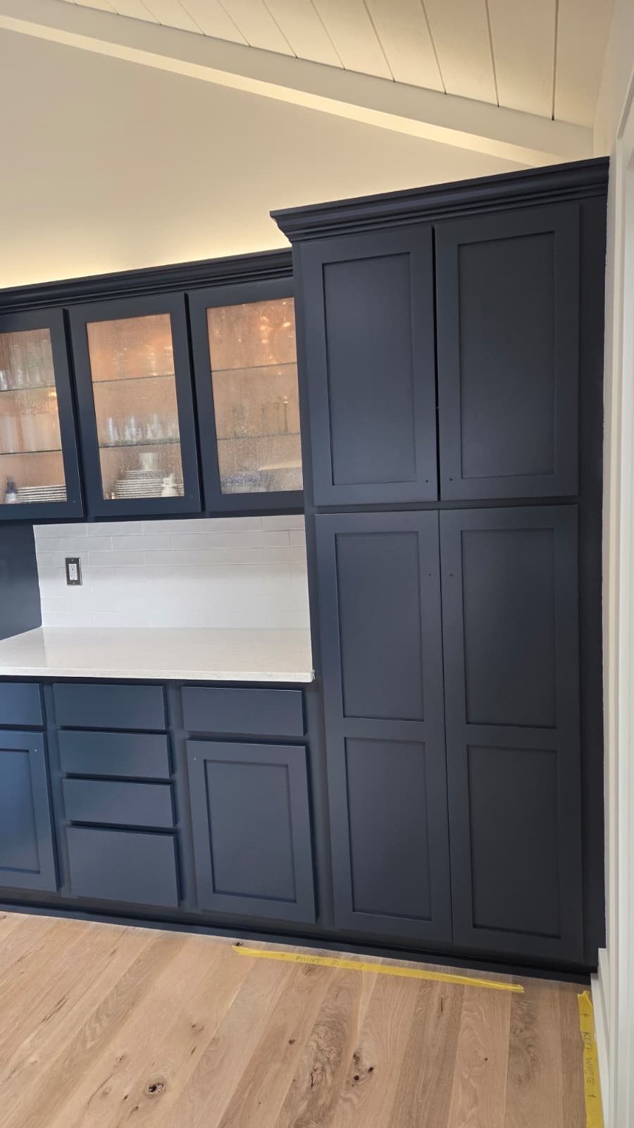 Custom navy blue pantry cabinet build-out with white countertop